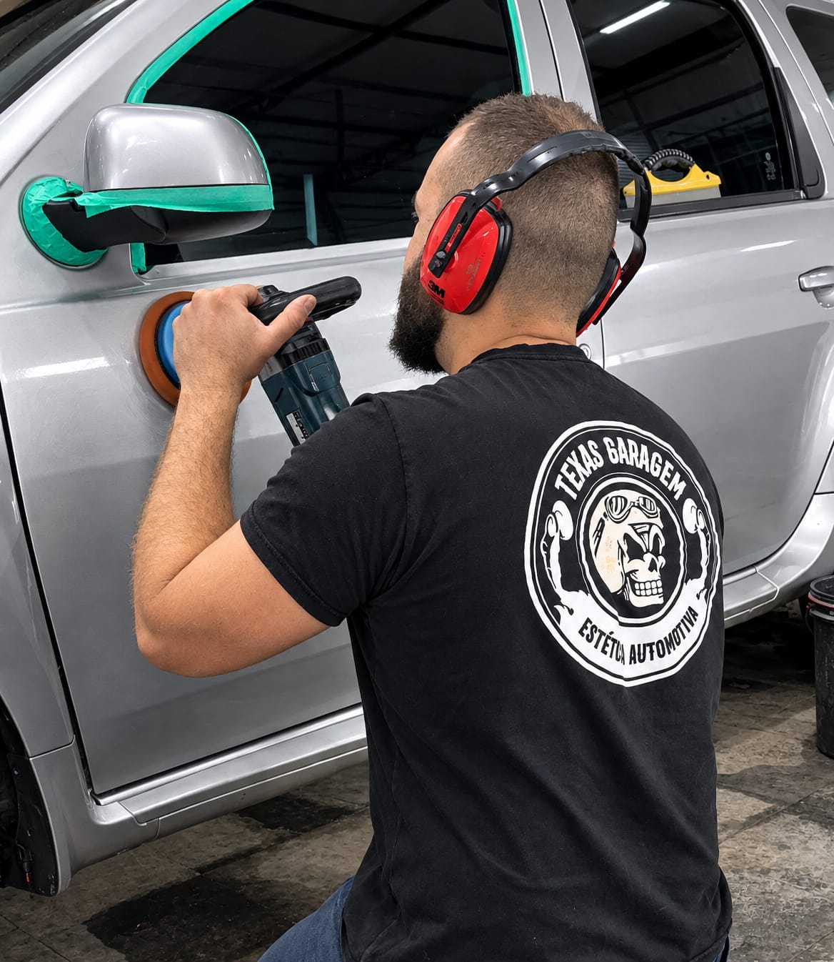 Profissional da Texas Garagem com camisa da marca realizando polimento automotivo