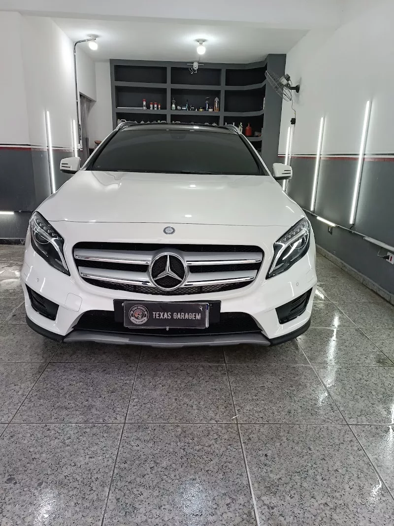 Mercedes-Benz GLA branco no box da Texas Garagem, com a placa de identificação da marca em frente ao veículo
