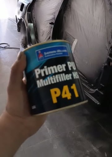Lata de primer PU multifiller P41 em frente a veículo em preparação de pintura